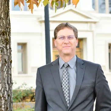 Judge William S. Abramson standing by a tree in front of the Plumas County Courthouse